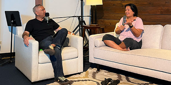 Claudine sits down on the couch with Pastor Dave