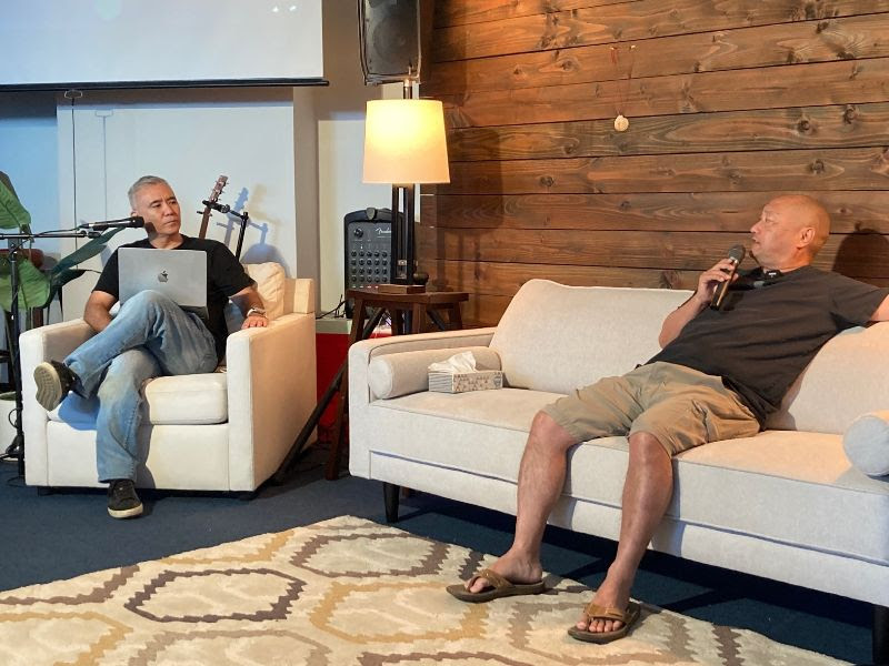 Grant sits down on the couch with Pastor Dave