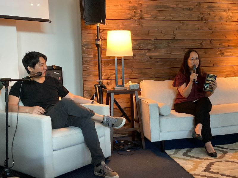 JoAnn sits down on the couch with John