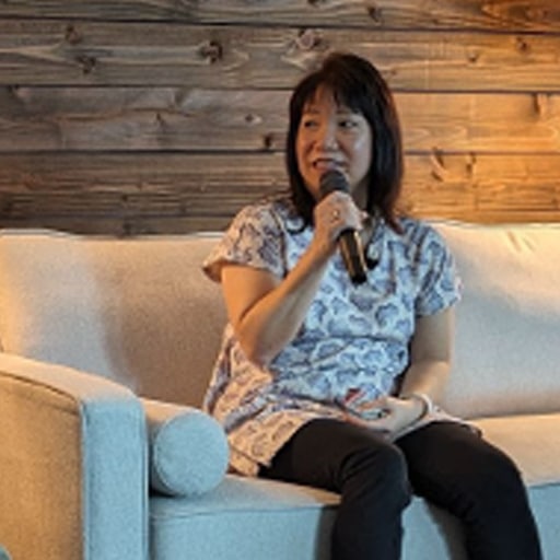 Photo of Patti sitting on couch with microphone